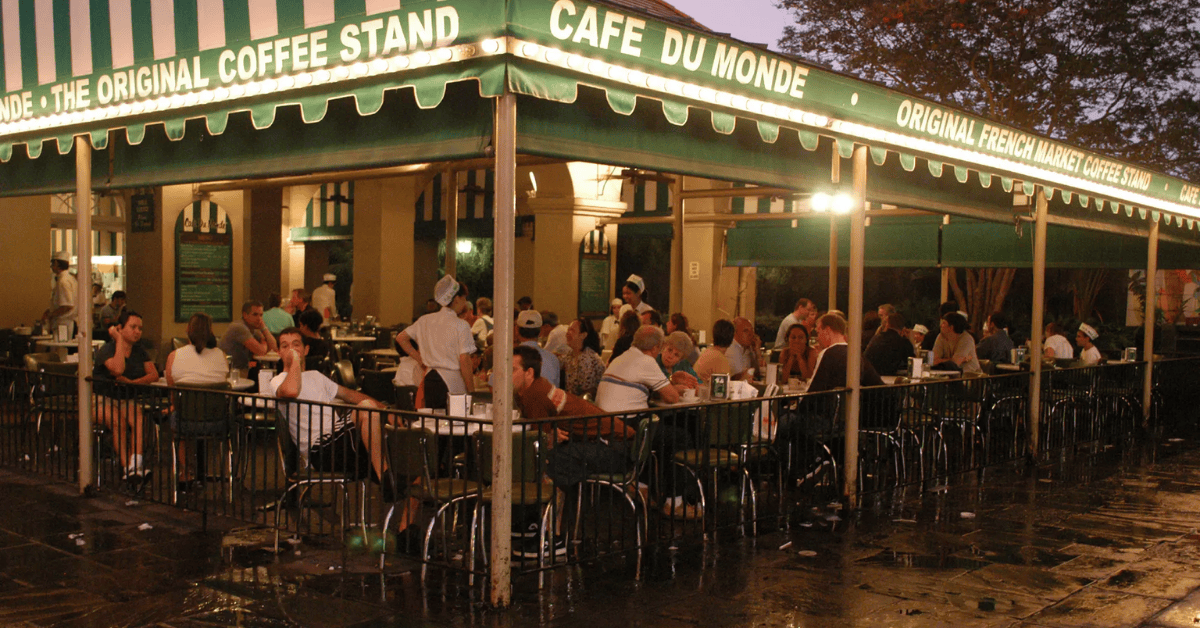 GroupSync | New Orleans for Group Travel | Crowds of people dining at the outdoor patio of Café du Monde