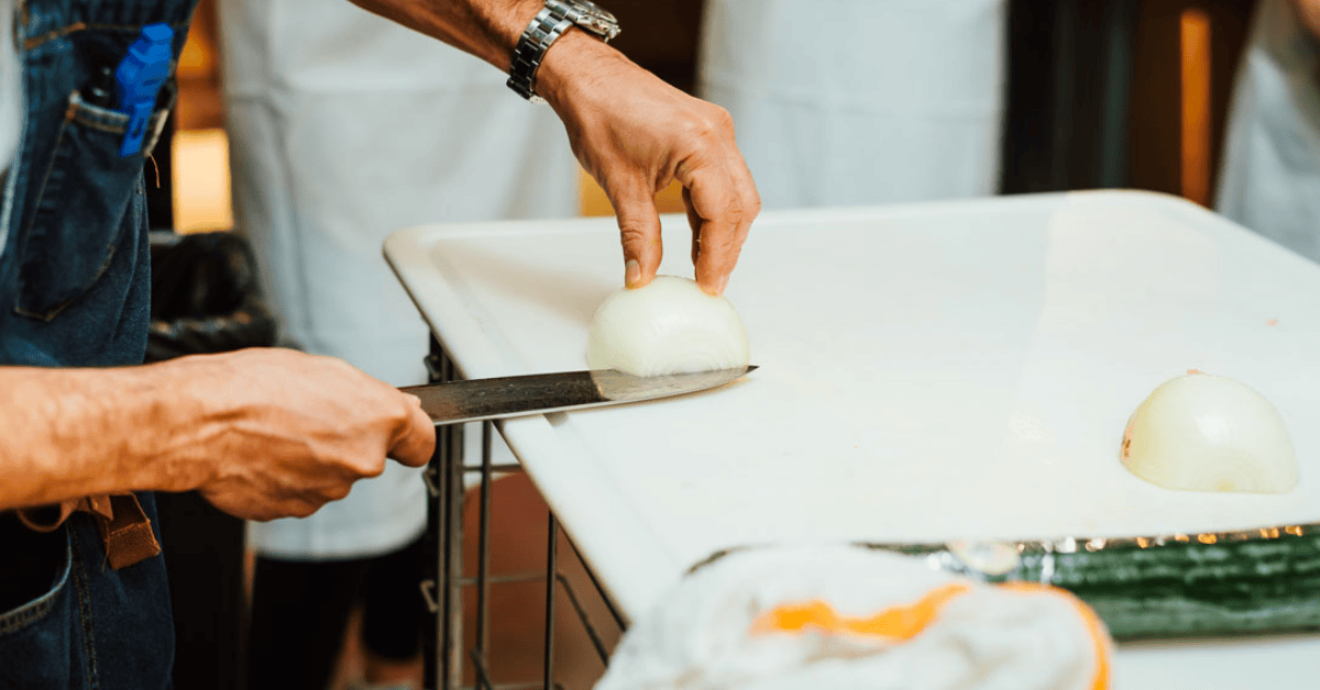 Chef cutting an onion in a restaurant kitchen