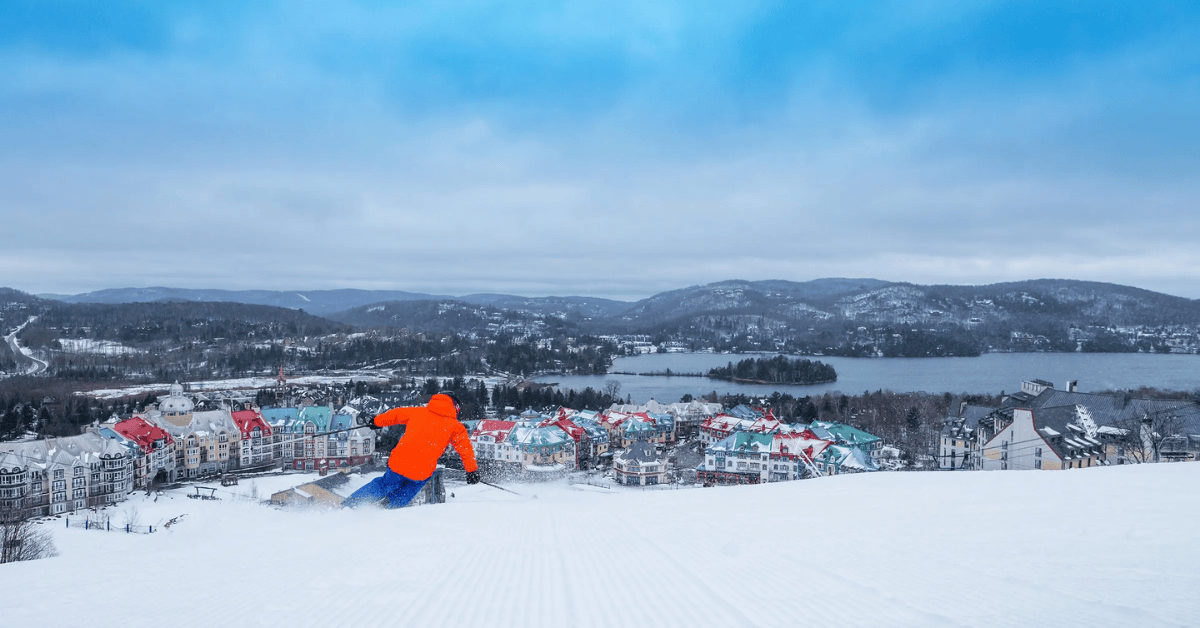 Skier overlooking a mountain town on a sunny day