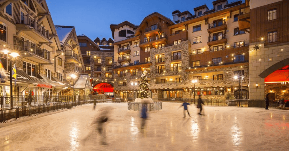 Ice skaters around a Christmas tree at the Madeline Hotel & Residences lit up at night