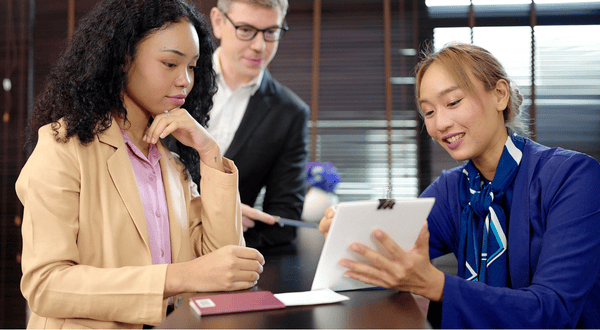 Hotel worker explaining a contract with two business professionals