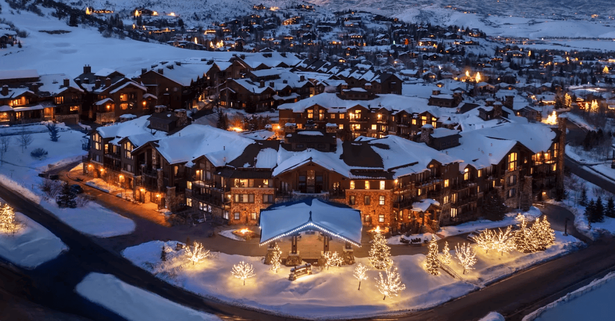 Sprawling snow covered hotel in the mountains lit up at night