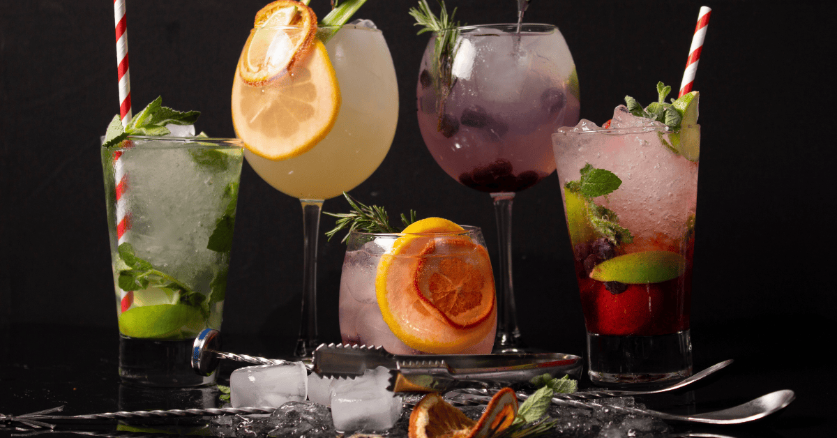 Cocktails garnished with fruit and herbs