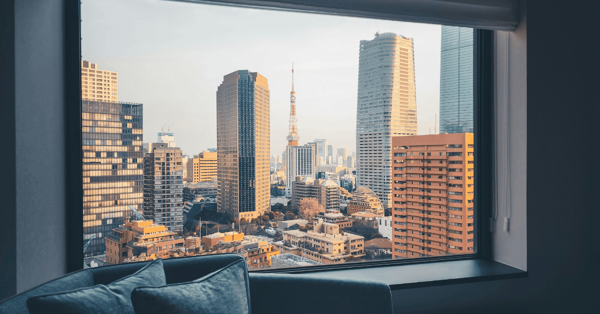 Hotel window overlooking large city buildings