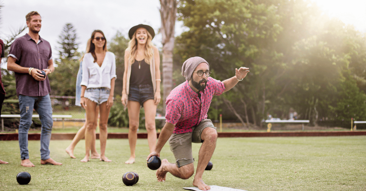 Group of friends playing bocce ball outside