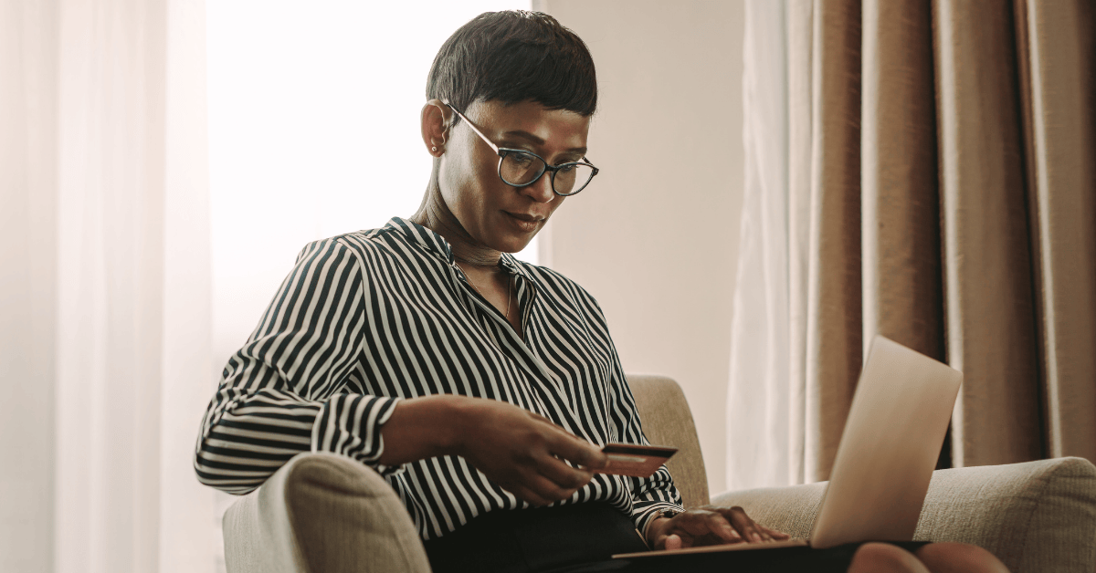 Professional woman entering credit card information into a laptop