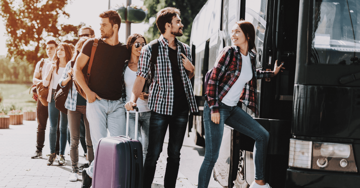 Group of happy travelers in line to get on a bus