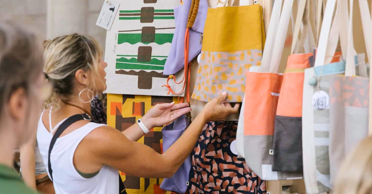 woman shopping looking at tote bags at Grand Central Market