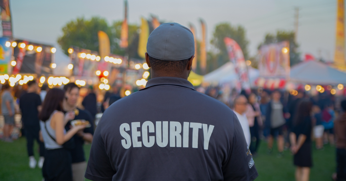 A security guard is controlling the traffic and parking situation at a festival
